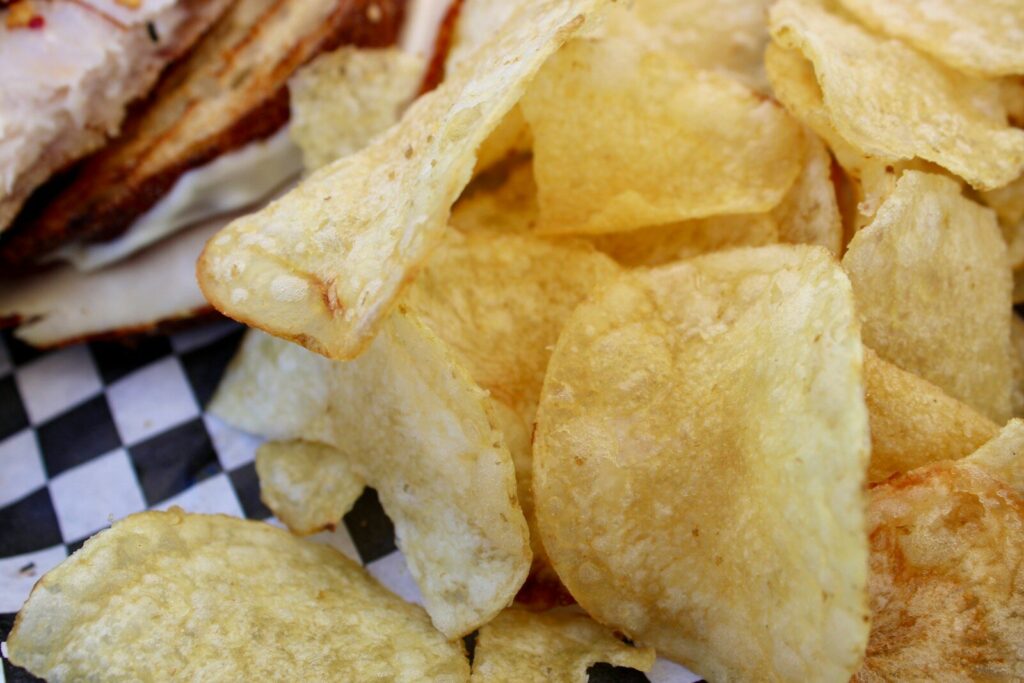 Crispy potato chips piled on checkered paper